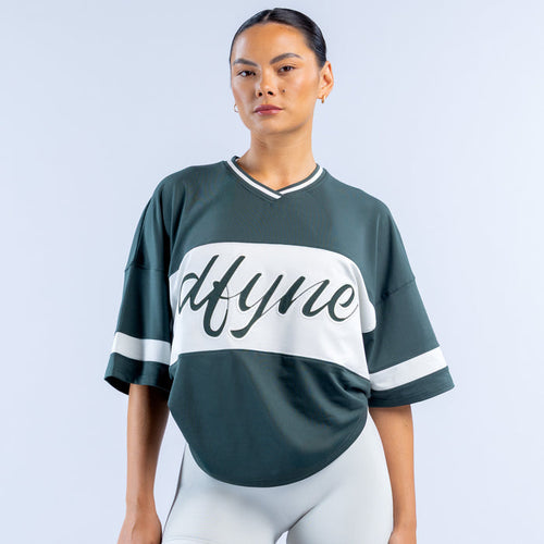 Dark green short sleeve top with white V-neck trim and large 'Mtyme' graphic