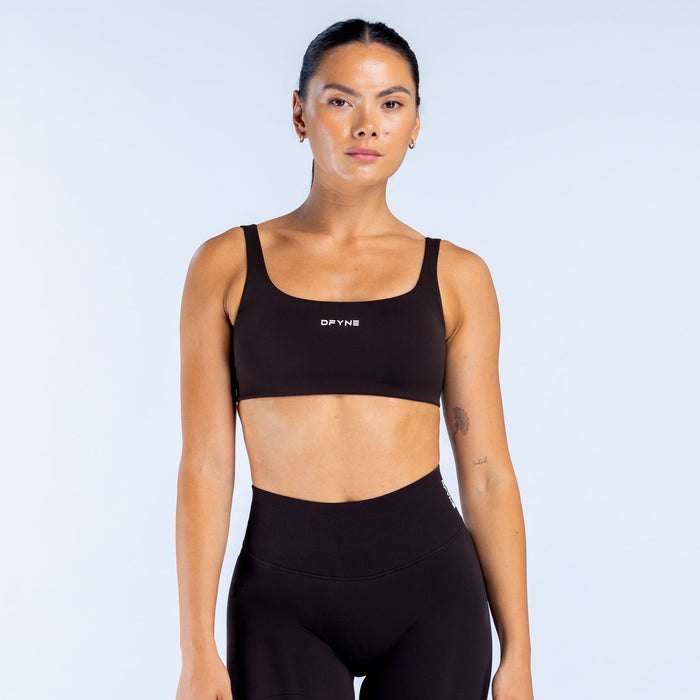 Black scoop back sports bra with scoop neckline and DPNY logo on front