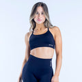 Dark sports bra with narrow shoulder straps and front logo