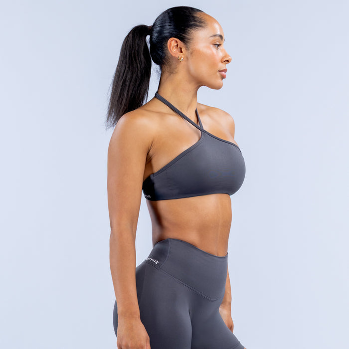 Dark gray high-neck halter sports bra, side profile with supportive racerback straps