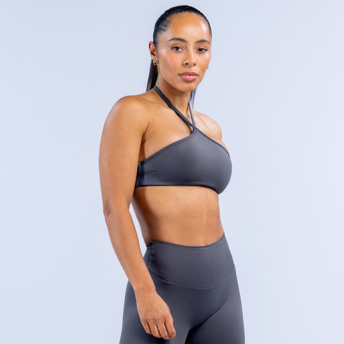 Dark gray high-neck halter sports bra with smooth front and thin crossover straps