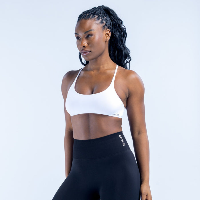 White twist-back sports bra with thin straps and snug scoop neckline