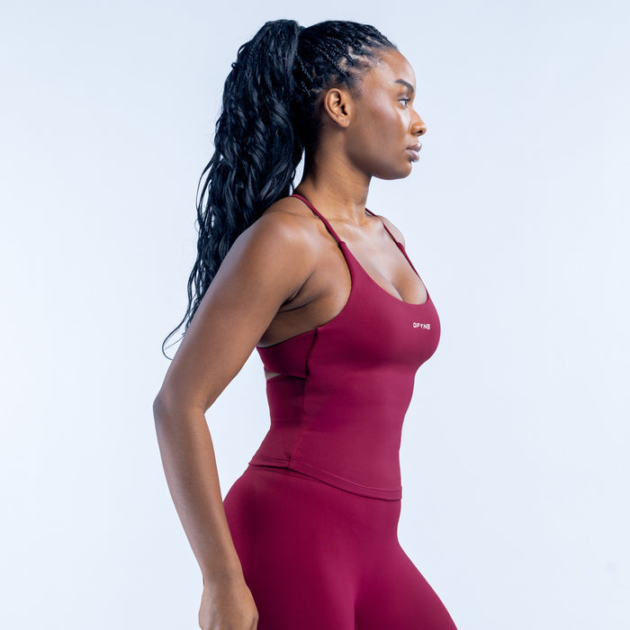 Burgundy twist-back sports top with crisscross straps, side view