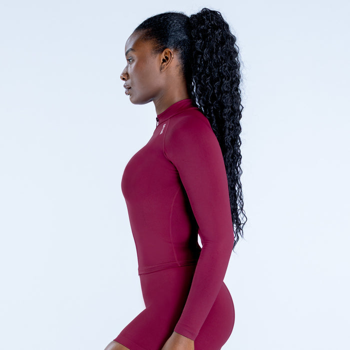 Burgundy long-sleeve zip athletic bodysuit, fitted side profile