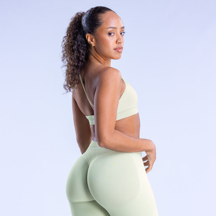 Asymmetric sports bra in light mint with racerback straps and wide back coverage