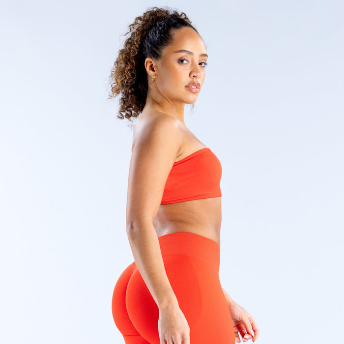 Red bandeau sports bra with smooth fabric and wide elastic backless band detail.
