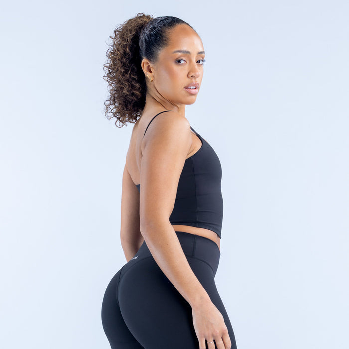 Black strappy sports crop top with racerback-style straps and cropped fit