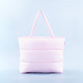 Light pink puffer tote bag with quilted panels and two top handles