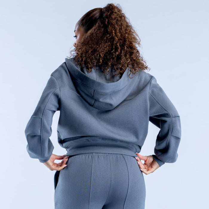 Blue zip-up hoodie with hood, back view showing waistband and full sleeves
