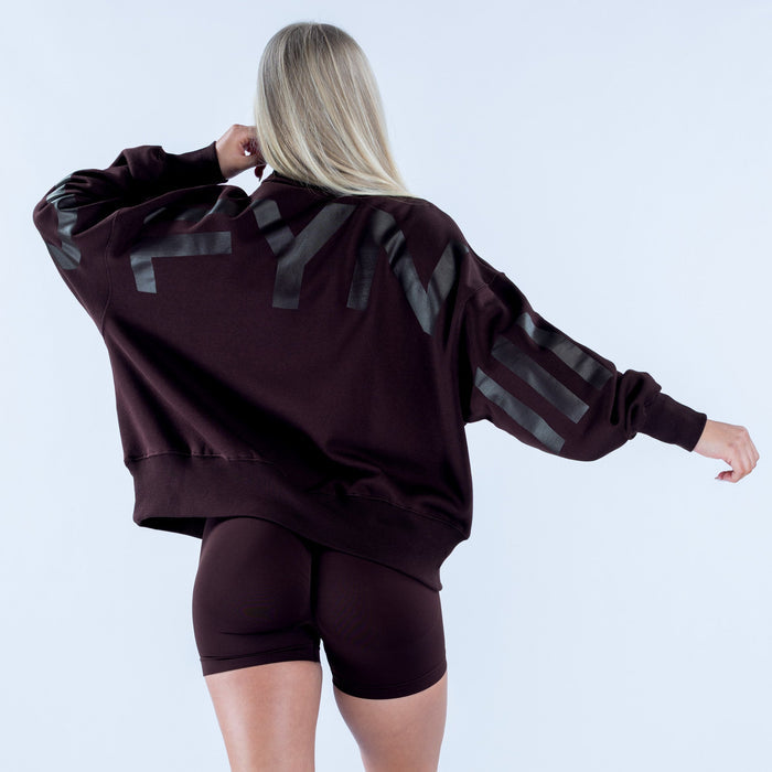 Back view dark plum quarter-zip sweatshirt with large gray patch graphic