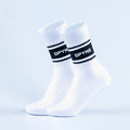 Pair of white crew sports socks with black stripe logo on cuff