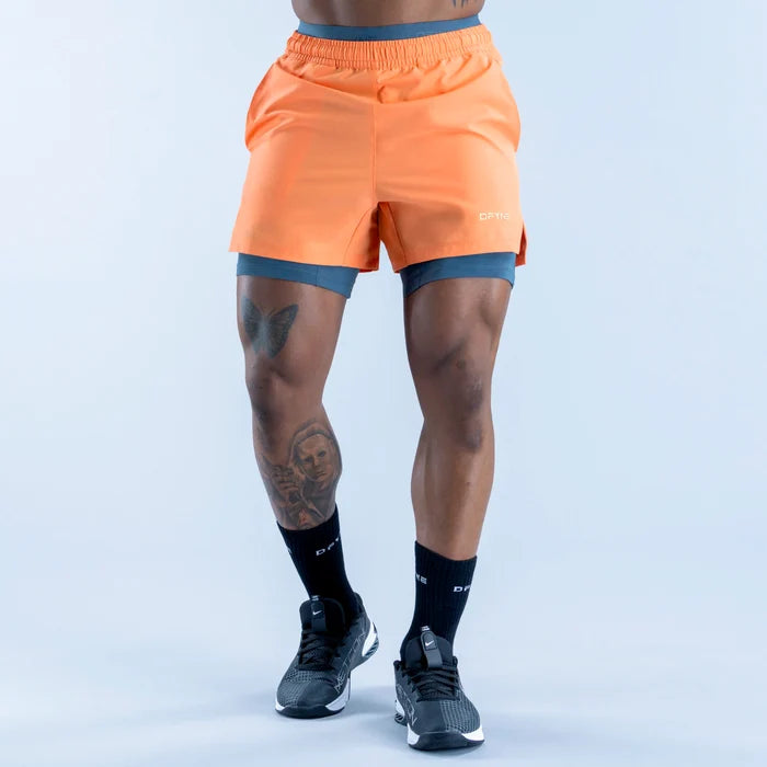 Unbound baselayer shorts in orange, form-fitting with waistband and stitched seams