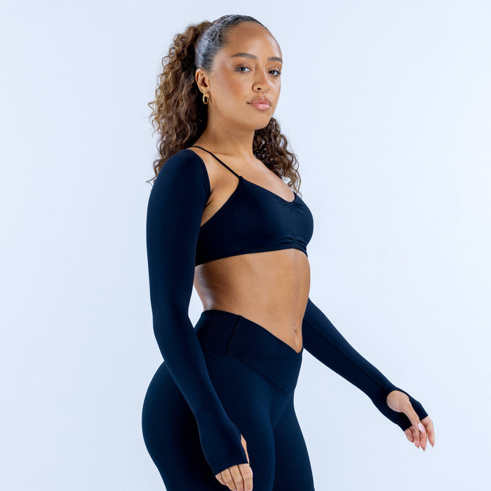 Navy long-sleeve shrug with thumbholes, worn over a sports bra