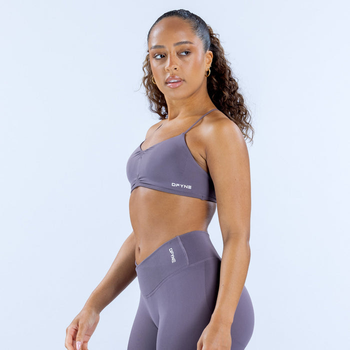 Women's sports bra in lavender with thin straps and logo at center front
