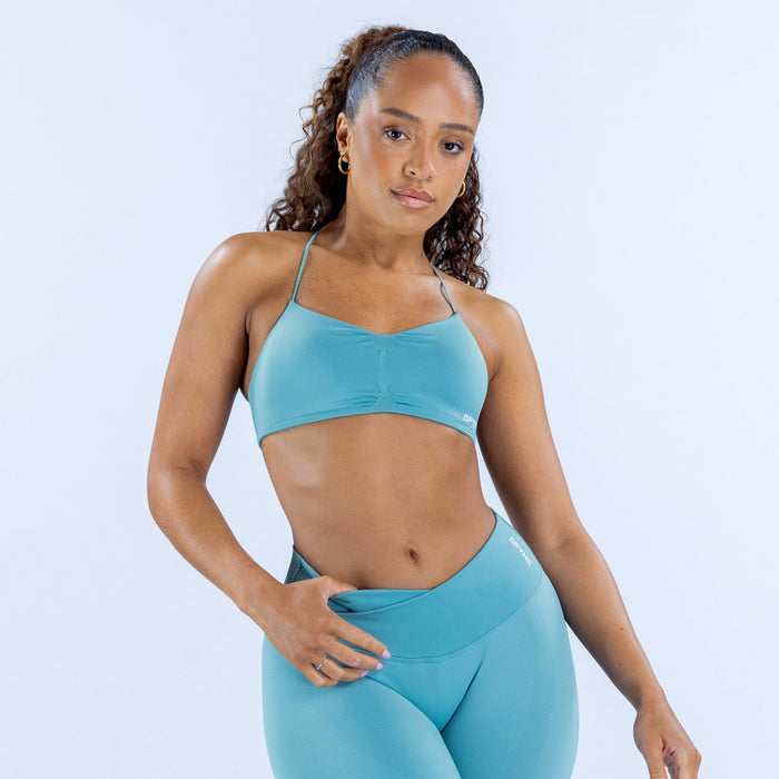 Teal sports bra with thin spaghetti straps and supportive molded front panel