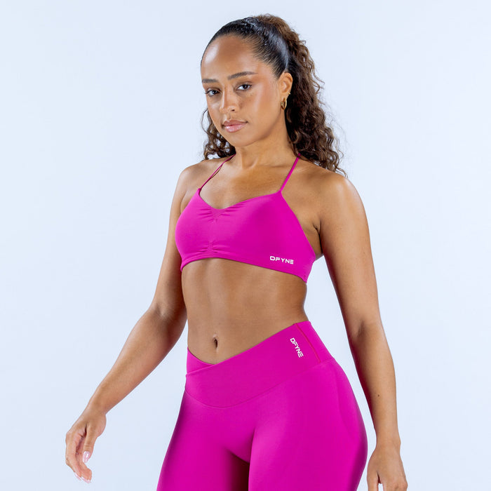 Fuchsia sports bra with thin straps and DYNE logo at center front