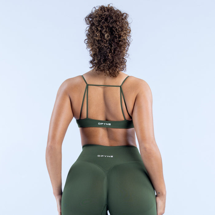 Green racerback sports bra with open back strap detail and DPYNE logo.